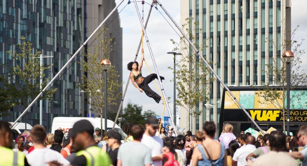 A circus performer suspended above a crowd in an illustration for For Miss La La